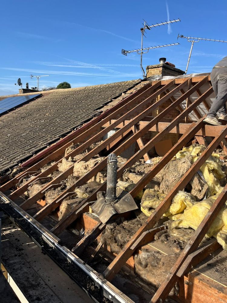 Roof stripped back to the rafters with the old insulation exposed